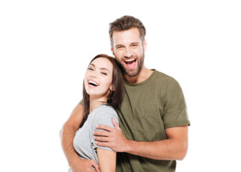 Image of cheerful young loving couple standing isolated over white background. Looking at camera.