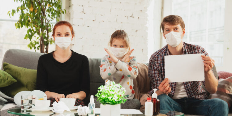 Kanserli Hastalar İçin Sosyal Destek Ağlarının Önemi 1 Caucasian famiy in face masks and gloves isolated at home with coronavirus respiratory symptoms such as fever, headache, cough in mild condition. Healthcare, medicine, quarantine, treatment concept.